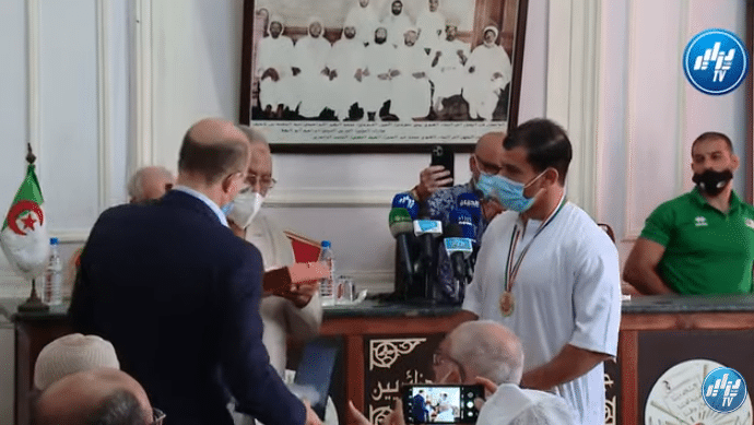 جمعية علماء المسلمين الجزائريين تكرم المصارع فتحي نورين ومدربه بميدالية ذهبية