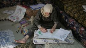 عجوز فلسطينية تحقق الشهرة بإبداعها في فنّ الرسم