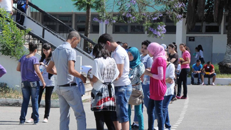 تلاميذ ينجزون وظائفهم المدرسية في الشارع