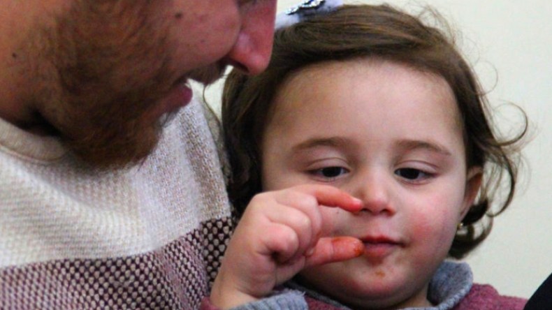 هكذا يحمي أب ابنته من القصف في شمال غرب سوريا