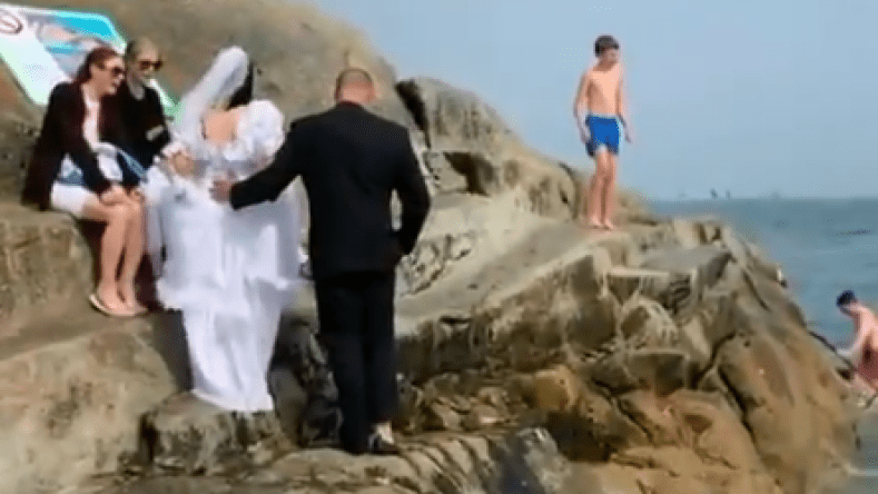 عروسان يحتفلان بزواجهما بالقفز في البحر بملابس الزفاف