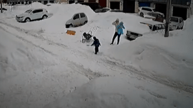 شاهد.. أم تنقذ طفليها من كومة ثلجية ضخمة