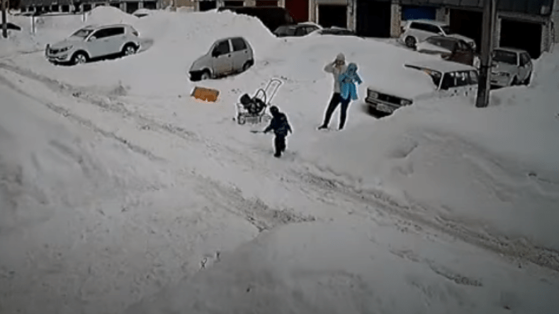 شاهد.. أم تنقذ طفليها من كومة ثلجية ضخمة