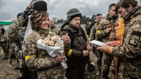 عروس أوكرانية ارتدت زيا عسكريا والعريس اعتمر خوذة