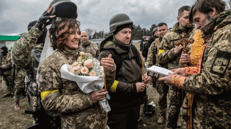 عروس أوكرانية ارتدت زيا عسكريا والعريس اعتمر خوذة