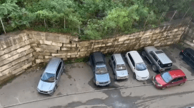 جدار ينقض فوق 7 سيارات (فيديو)