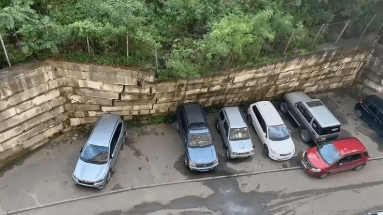 جدار ينقض فوق 7 سيارات (فيديو)