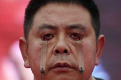 رجل صيني يرفع 4 كجم بجفون عينيه