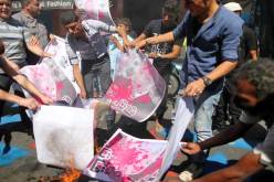 فلسطينيون يحرقون صوراً لرئيس الكيان الصهيوني بيريز تنديدا بمشاركة عباس في جنازته