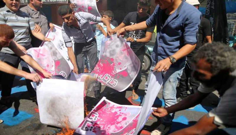 فلسطينيون يحرقون صوراً لرئيس الكيان الصهيوني بيريز تنديدا بمشاركة عباس في جنازته
