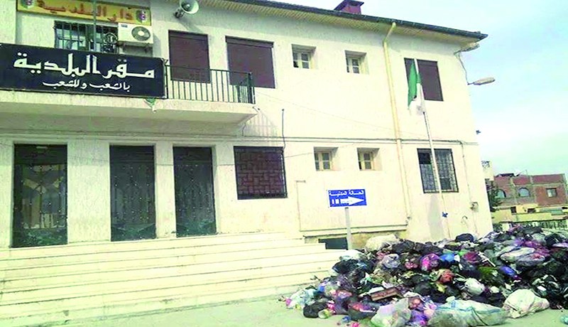 مواطنون يفرغون شاحنتي قمامة أمام مقر بلدية شعبة العامر في بومرداس