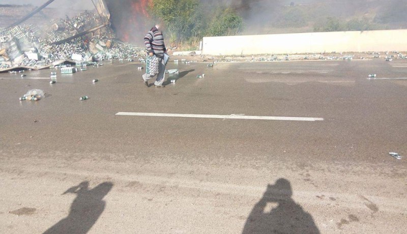 بالصور.. حريق يلتهم شاحنة لنقل الخمور وبعض المارة يسطون على علب الجعة