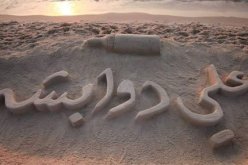 بالصور فنان فلسطيني يرسم اسم الرضيع علي دوابشة على رمال غزة