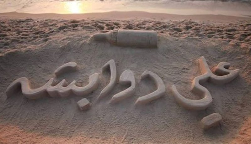 بالصور فنان فلسطيني يرسم اسم الرضيع علي دوابشة على رمال غزة