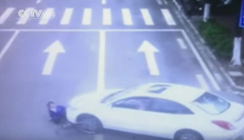 بالفيديو صينيون يحملون سيارة لإنتشال أحد المارة من تحتها بعد حادث مرور