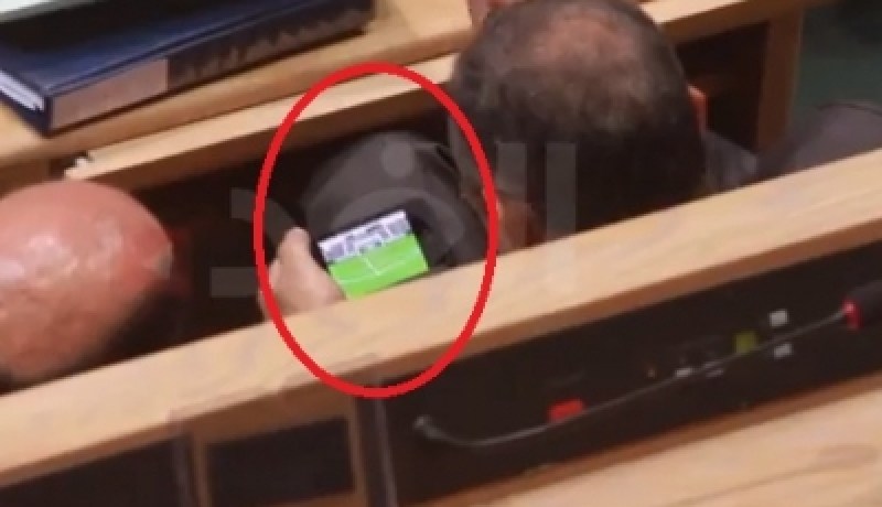 وزير أردني ينشغل باللعب أثناء كلمة رئيس الحكومة