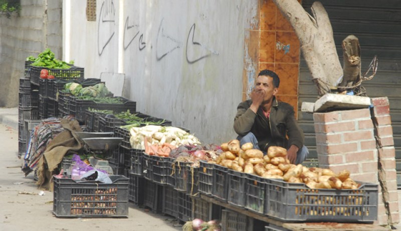 يبدو هذا الخضّار الذي يفتقد للزبائن في حالة صعبة لاسيما وأن جذع الشجرة يكاد ينهار عليه ولم يحضر أي زبون!!