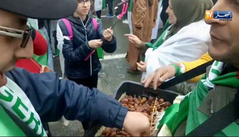 شاهد تلاحم الجزائريين…مواطن يوزع التمر على المتظاهرين بالعاصمة