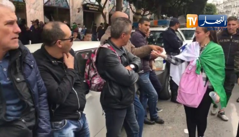 فتاة توزع الحلوى لرجال الأمن أثناء المظاهرات السلمية بالعاصمة