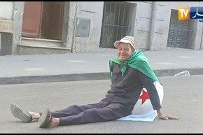 شاهد.. عجوز يجلس أرضا بعد أن أنهكه الصيام والتعب في مسيرة الجمعة الـ 12