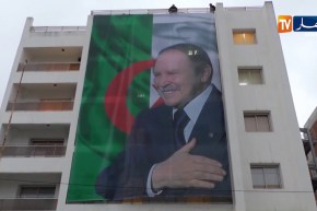 لحظة إسدال صورة الرئيس بوتفليقة على مقر حملته الرئيسي