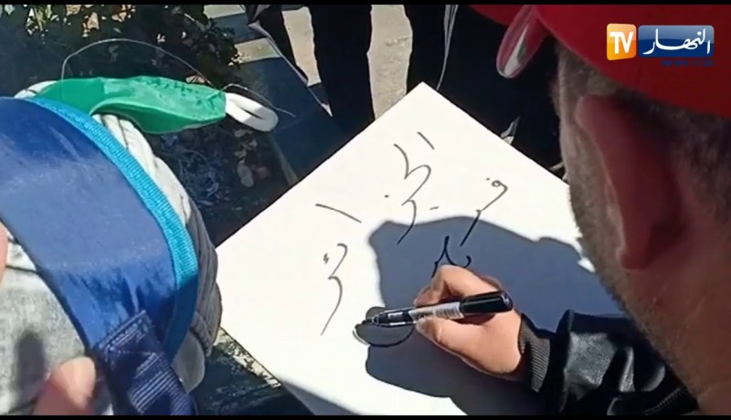 مواطن يوزع اللوحات والأقلام على المتظاهرين لكتابة شعاراتهم مجانا خلال المسيرة