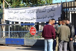 عمال يقفون أمام مدخل مصنع الأحذية بشراقة أمس، ليس للإضراب عن العمل، وإنما مدير المصنع أغلق الباب أمامهم،فضلا عن ذلك لم يتقاض هؤلاء رواتبهم منذ 7 أشهر.