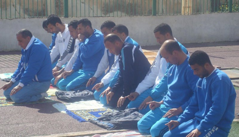 مدرب فريق اولمبي ارزيو، السيد نجيب مجاج، يؤم لاعبيه في صلاة الظهر قبل انطلاق المباراة