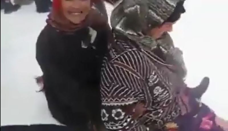 بالفيديو عجائز يشاركن الأطفال فرحتهم باللعب والتزحلق على الثلوج