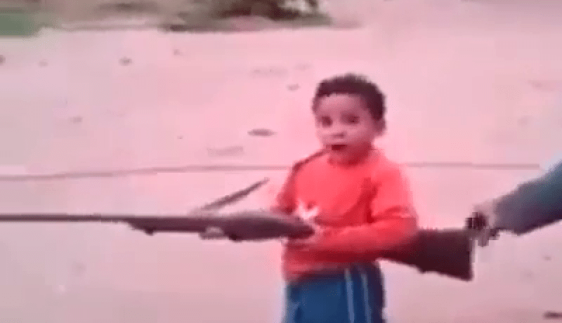 فيديو خطير وغريب لأب يعلم ابنه استعمال السلاح الناري